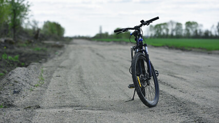 Mountain bike. stands on a field road. spring or autumn. concept of cycling, repair or breakage, sports, outdoor activities. bike on trail, front wheel in focus. healthy lifestyle