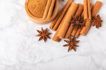 Cinnamon sticks and anise on a textured background. Cinnamon roll and star anise. Spicy spice for baking, desserts and drinks. Fragrant ground cinnamon.Place for text. copy space.