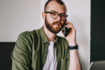 Portrait of hipster guy 20 years old sitting in at university cafeteria for studying using new...