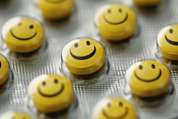 close up of yellow smiley pills