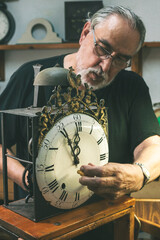 Front shot of a watchmaker repairing a large antique clock.