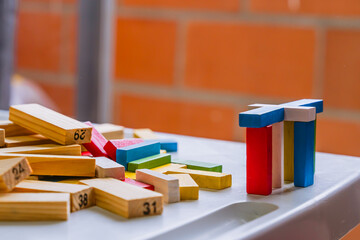 International Children Day. Beautiful Latino children playing with blocks on a white table. Playful, fun and thinking games. Happy children at home. - obrazy, fototapety, plakaty
