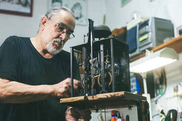 Portrait of a watchmaker repairing the machinery of an old clock.