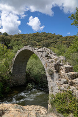 Fototapeta na wymiar View of the remains of the medieval Roman bridge of Alcanzorla, on the Guadarrama river, Galapagar, Community of Madrid.