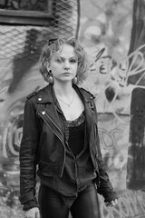 Beautiful cool caucasian white young woman posing. Finnish model with black leather jacket, sunglasses in a black and white street photography.