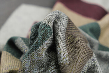 Close-up of knitted cashmere fabric texture, stripes of green, gray and brown, textured patern.