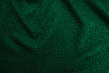 Texture of draped wool emerald green fabric, top view, textured background.