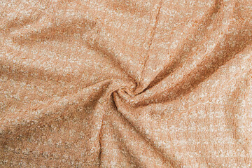 Texture of draped wool  light orange fabric with stripes, top view, textured background.