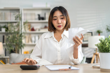 Obraz premium Smiling asian woman using calculator and calculate bills on laptop, paying bill, credit card, finance, tax, vat, credit card, payment, tax refund, budget, debt, money.financial and accounting concept