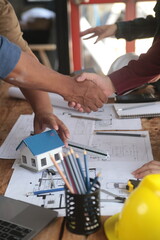 Engineer and contractor join hands after signing contract,They are having a modern building project together. successful cooperation team concept