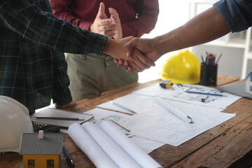 Engineer and contractor join hands after signing contract,They are having a modern building project together. successful cooperation team concept