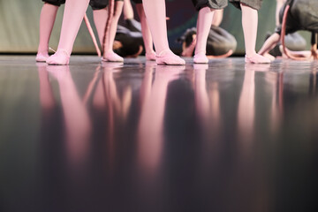A group of dancers in different poses are standing on the stage. Children performing art on stage....