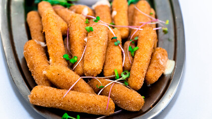 Fried crispy breaded cheese sticks with golden crust and herbs