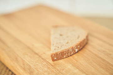Close-up of one slice of a loaf of dark rye bread on the background of a wooden board. High quality photo
