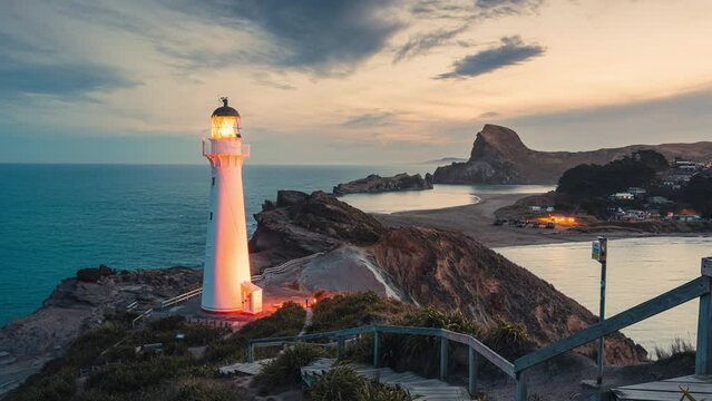 Castlepoint lighthouse glowing on Wairarapa coastline in the sunset at New Zealand
