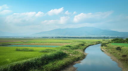 A picturesque landscape of vibrant green rice fields and a gentle water stream with mountains in the distance, depicting rural serenity