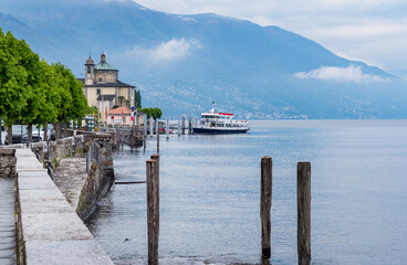 The pier with a ferry boat in Cannobio on the lake Maggiore, province of Verbano Cusio Ossola in...