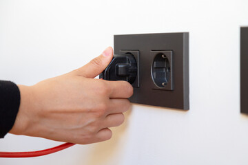 Woman's hand plugging in electrical appliance