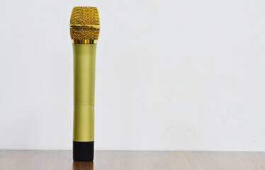 The microphone is placed on a wooden table, on a white background with copy space