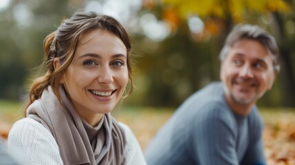 Happy couple enjoying a bicycle ride in a park filled with autumn leaves