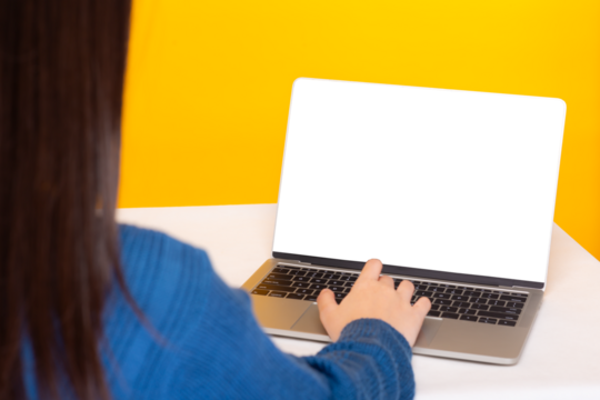 Woman Working on Laptop with Blank Screen,Rear view of a woman using a laptop with a mock-up screen against a vibrant yellow background.
 - Powered by Adobe