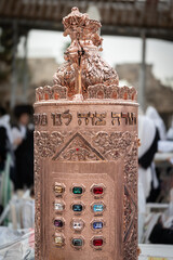 A decorative, Sephardic style Torah in a copper case with 12 jewels of the breast plate worn by the...