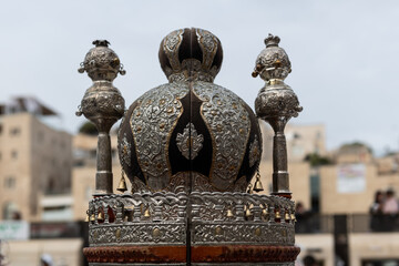 A decorative,  silver crown which sits atop the Sephardic-style case holding the Torah scroll which is read during Jewish prayer services at the Western Wall in Jerusalem.