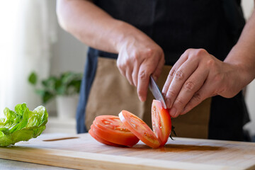 Person cutting ingredients for a hamburger
