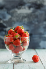 A glass full of strawberries on table.