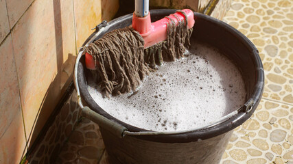 A mop and a bucket of soapy water.