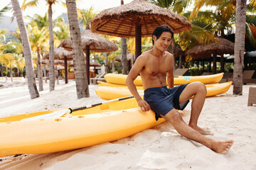 Happy Asian Man Experiencing Adventurous Kayaking on Tropical Beach