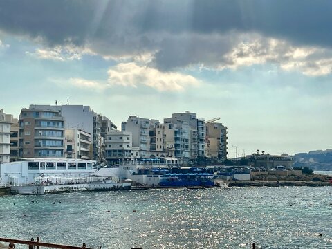 view of the seaside of the seaside resort of Bugibba in Malta in St Paul's Bay on a summer day with threatening clouds
