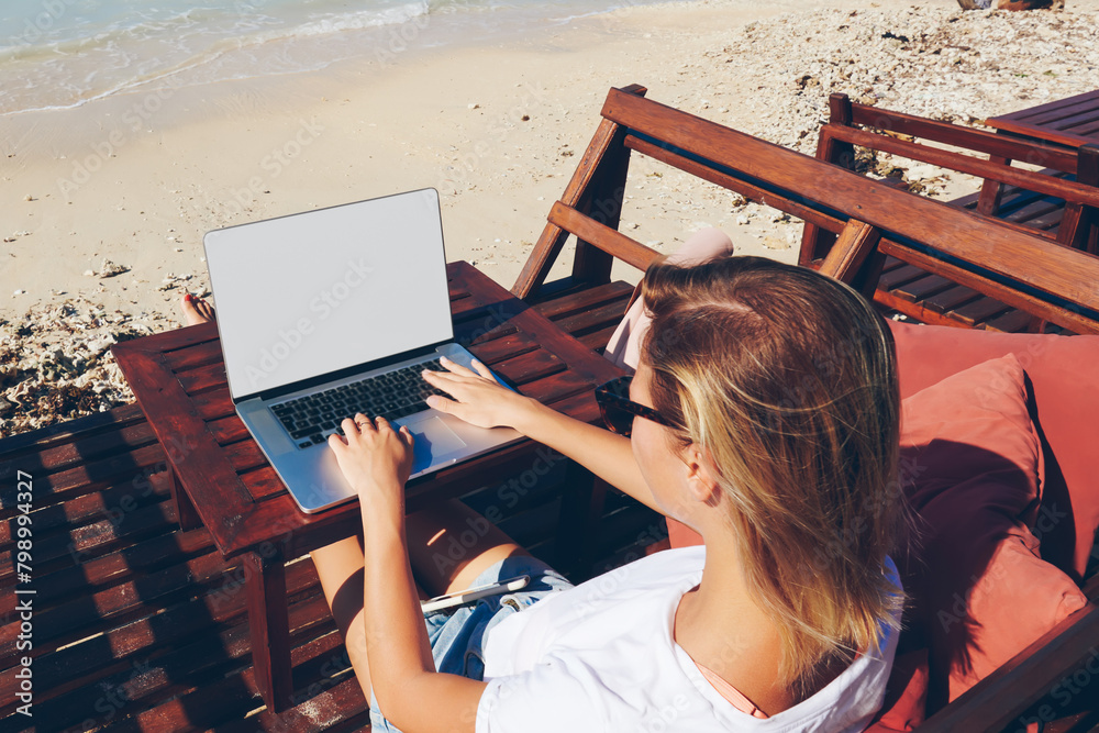 Wall mural skilled female millennial freelancer keyboarding on laptop computer with mock up screen working remo