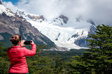 Mujer turista tomando fotografias de los paisajes patagonicos de los senderos de El Chalten