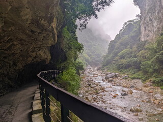 Taroko, Taiwan - 11.26.2022: Dark and empty Shakadang Trail goes under a cliff alongside Liwu River...