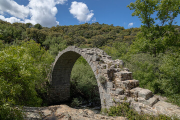 Fototapeta na wymiar View of the remains of the medieval Roman bridge of Alcanzorla, on the Guadarrama river, Galapagar, Community of Madrid.
