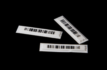 Close-up with anti-theft barcodes on a black background. Anti-theft systems in stores