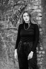 Portrait of a young beautiful girl in dark clothes. Black and white photo.