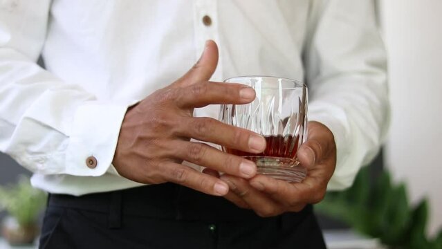 A man is holding a glass of drink.