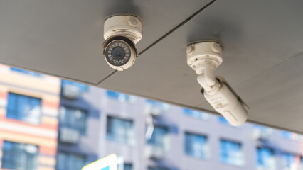 Outdoor CCTV Cameras. Two white cameras of residential neighborhood security system close-up....