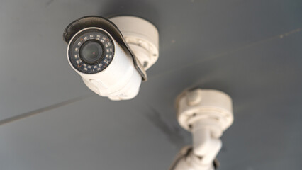 Outdoor CCTV Cameras. Two white cameras of residential neighborhood security system close-up....