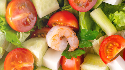 A close-up salad of fresh vegetables, a plate of fresh salad with vegetables and herbs. Greek salad with juicy tomatoes, feta cheese lettuce leaves green olives cucumber, fresh parsley. Homemade food.