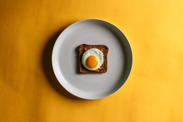 fried egg on a plate with brown bread toast