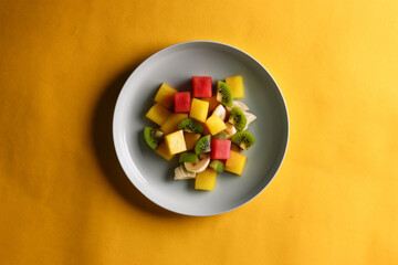 Healthy fruit salad kept on a white plate