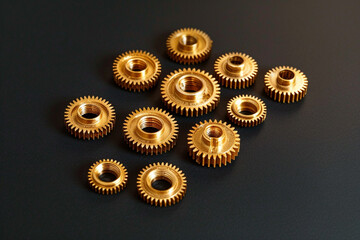 The gold gears isolated in black background. Concept of precision and engineering. - obrazy, fototapety, plakaty