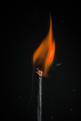 burning wooden match on a black background. Match head with burning gray at the end, flame, copy space. Creative banner of energy, fuel industry.