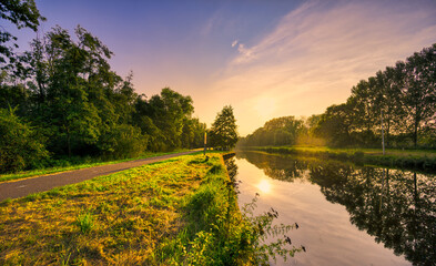 Sunset light playing with the rural landscape of Noord-Brabant, The Netherlands. The canal is...