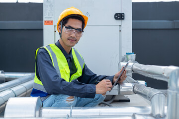 Engineer checks valves, water tanks, pumps and equipment related to hot water production pipe...