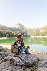 Young woman sitting on the hill and enjoying nature. Active life. Lifestyle, travel, tourism