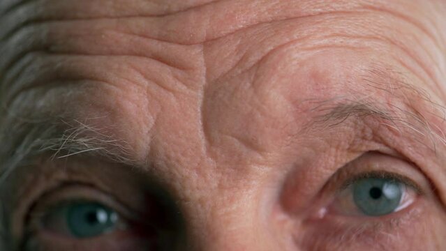 Close-up of a man raising his eyebrows and furrowing his forehead
